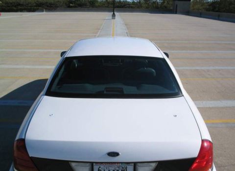 1998 Ford Crown Victoria - A white sedan is parked in an empty lot, viewed from directly above the rear.