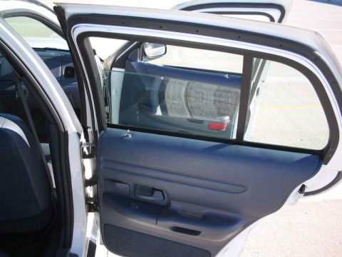 1998 Ford Crown Victoria - Interior view of the driver's side rear door panel and window on a 1998 Ford Crown Victoria.