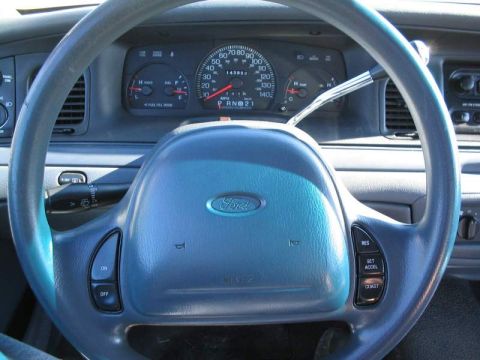 1998 Ford Crown Victoria - The dashboard and steering wheel of a 1998 Ford Crown Victoria are visible in this interior shot.