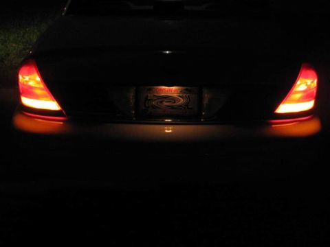1998 Ford Crown Victoria - The rear of a 1998 Ford Crown Victoria is visible with its taillights illuminated.