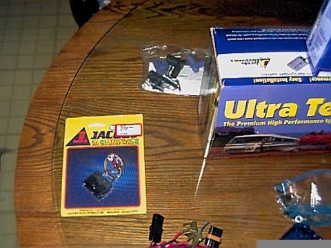 1994 Ford Bronco - Packaging for Jacobs Electronics and an Ultra Tech box are displayed on a wooden table, with some electronic components visible.