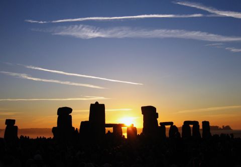 2000 Ford Crown Victoria - Stonehenge monument silhouetted against a sunrise sky with wispy clouds.