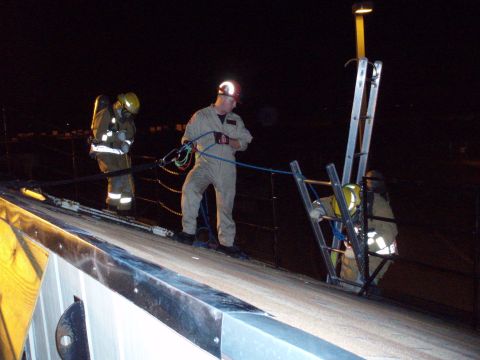 1981 Ford Bronco - Firefighters are seen on a rooftop at night, engaged in what appears to be a training or rescue operation.
