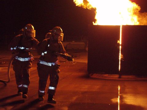 1981 Ford Bronco - Firefighters train with a large controlled fire, practicing hose techniques in a dark environment.