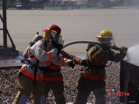 1981 Ford Bronco - Two firefighters train with a hose, simulating a response scenario.