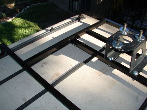 1996 Ford Bronco - A black metal spare tire carrier mount is shown on a concrete surface, with a grassy area in the background.