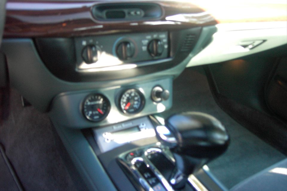 Car center console with twin auxiliary gauges and automatic shifter, wood trim