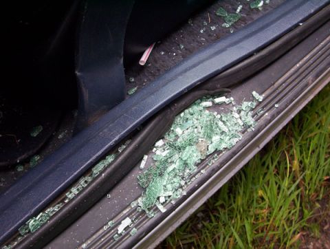 1995 Mercury Cougar - Shattered glass litters the interior of a vehicle door, indicating a broken window.