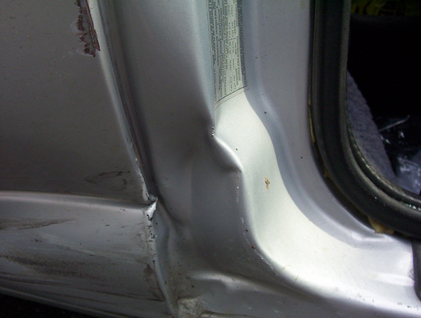 Close-up of a silver vehicle door jamb and B-pillar area