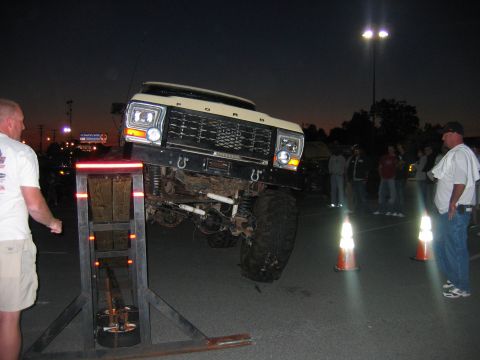1992 Ford Mustang - A lifted Ford truck is positioned on a ramp, with onlookers observing the event.