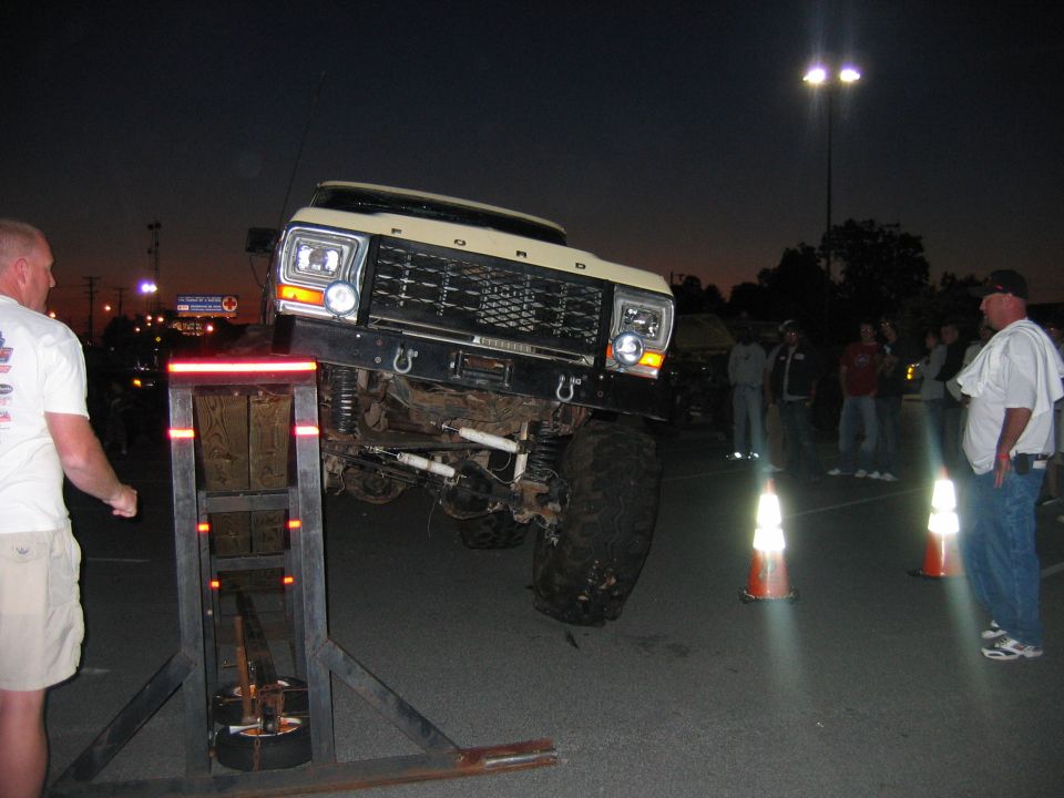 Lifted Ford truck on a ramp, front view. People watching