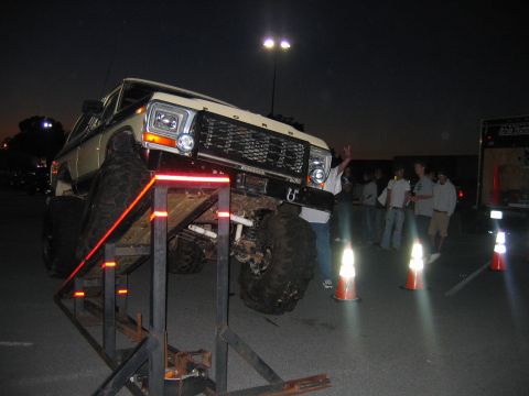 1992 Ford Mustang - A heavily modified 1979 Ford F-Series truck is positioned on a ramp during an event at night.