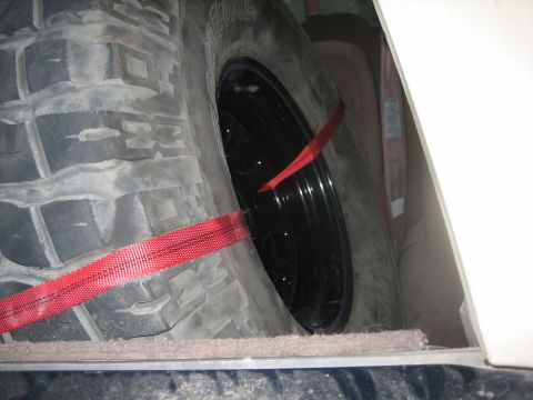 1995 Ford Bronco - Spare tire and wheel assembly, secured with red straps, is visible within the cargo area.