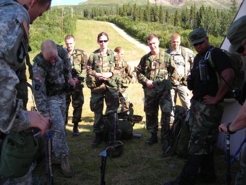 2003 Jeep TJ - A group of soldiers in camouflage uniforms stand together outdoors, preparing for an activity.