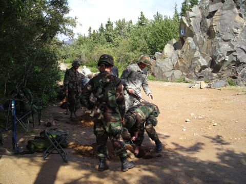 2003 Jeep TJ - A group of soldiers are engaged in digging activities outdoors in a wooded, rocky area.