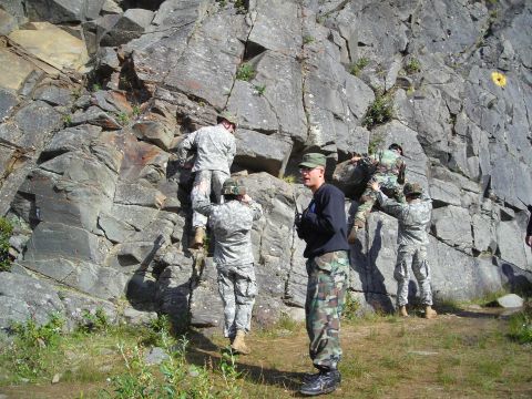 2003 Jeep TJ - Military personnel engage in a rock climbing exercise on a cliffside, demonstrating teamwork and physical training.