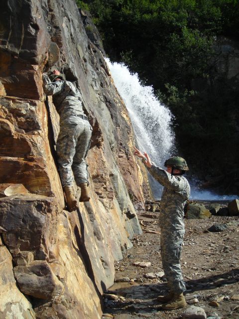 2003 Jeep TJ - Two soldiers practice climbing a steep rock formation next to a cascading waterfall.