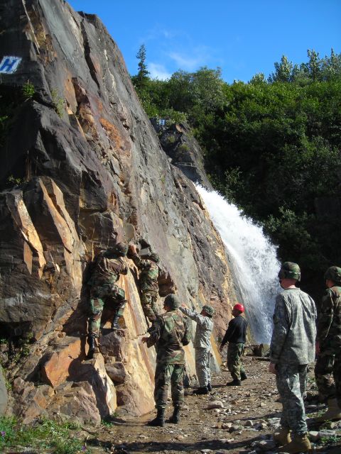 2003 Jeep TJ - Soldiers practice rock climbing near a waterfall, with a marked 'H' on the cliff face.