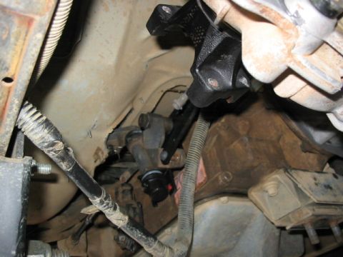 1995 Ford Bronco - Transfer case linkage and associated parts are visible in this undercarriage shot.