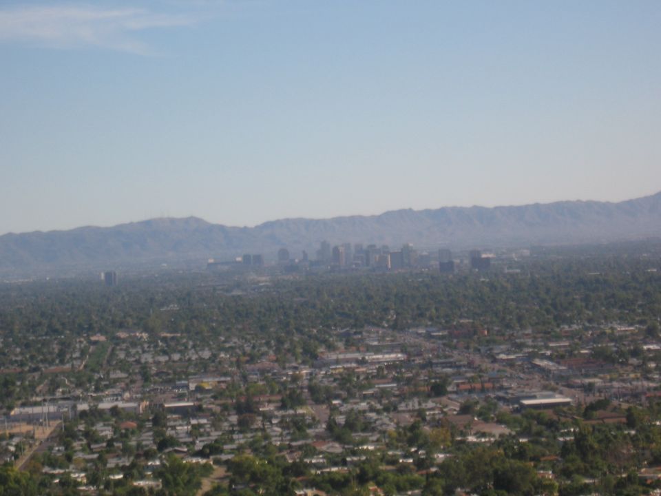 Distant city skyline with mountains in the background, seen from a high vantage point