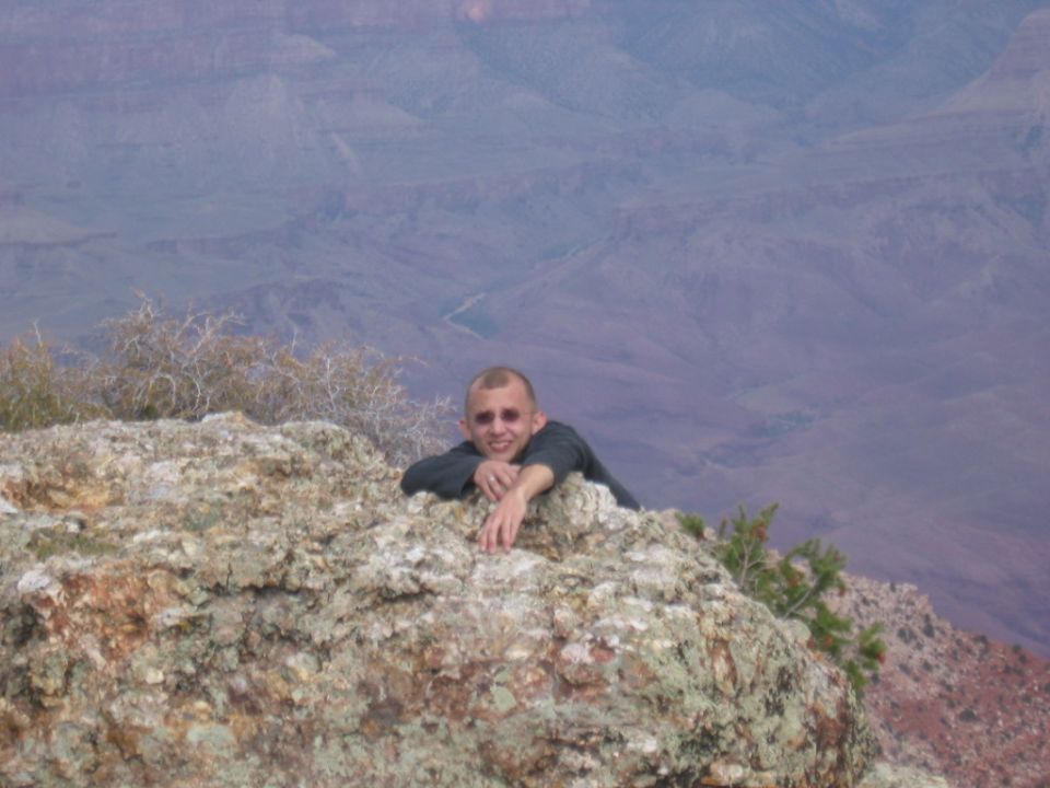 guy on rock overlooking grand canyon
