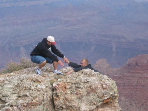 1995 Ford Probe - A dramatic rescue scene unfolds on a rocky precipice, with one person extending a hand to another in peril.