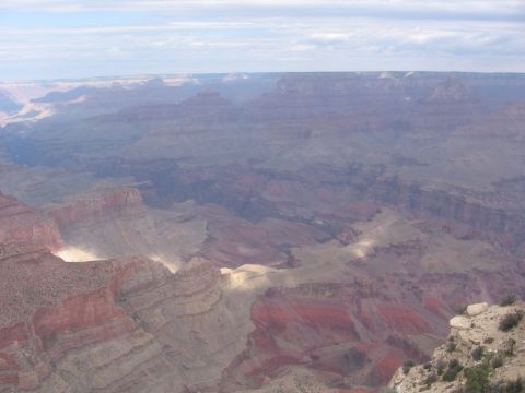 1995 Ford Probe - The Grand Canyon's vastness is captured under a partly cloudy sky, its colorful geological strata.