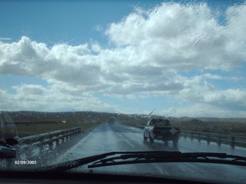 1995 Ford Probe - A view from inside a vehicle looking out at a pickup truck on a wet highway, with rain on the windshield.