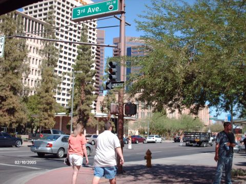 1995 Ford Probe - A street scene in a city with buildings, trees, traffic, and pedestrians on a sunny day.