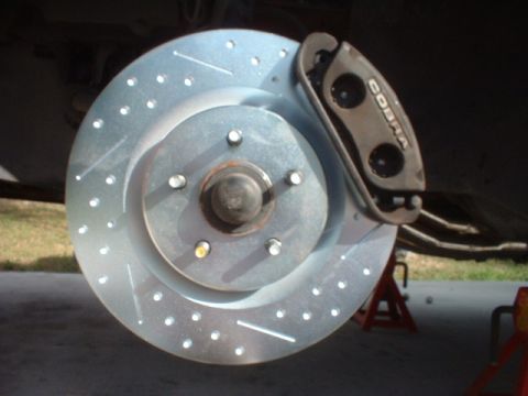 1993 Ford Taurus - Aftermarket Cobra brake caliper and drilled rotor assembly shown on a vehicle.