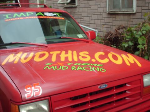 1991 Chevrolet Blazer - This red SUV features prominent racing decals on its hood and fender, suggesting it's used for off-road events.