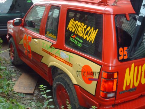 1991 Chevrolet Blazer - This red SUV is heavily customized with racing decals and graphics, including 'MUOTHIS.COM' and the number '95'.