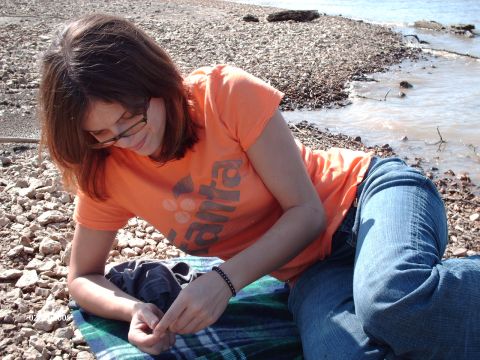 1995 Ford Probe - A woman relaxes on a blanket by the water's edge on a sunny day.