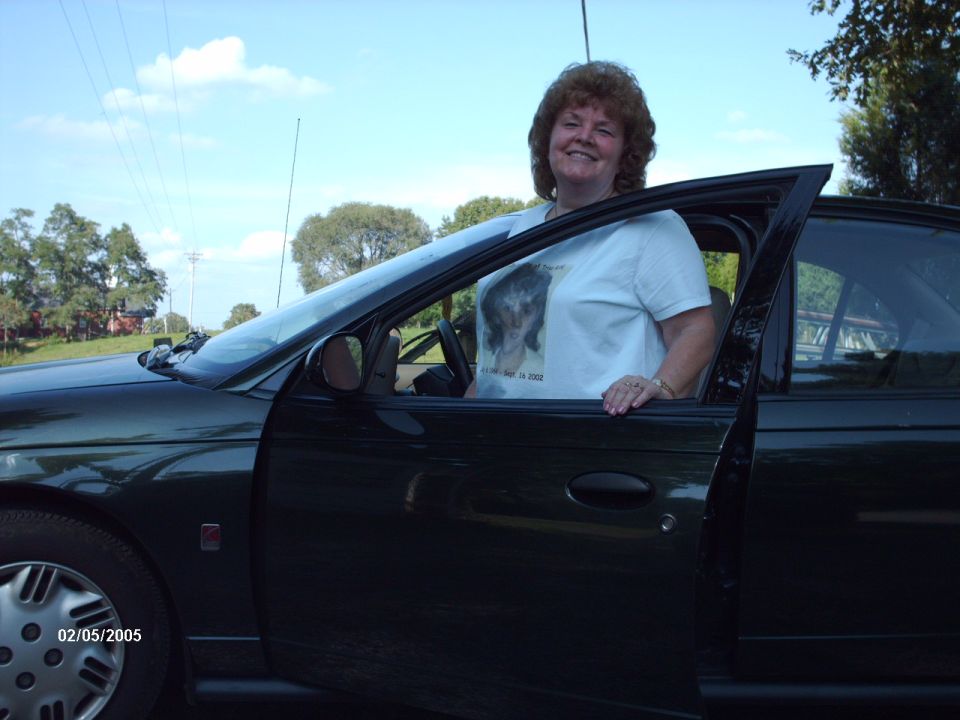 Dark green car with woman leaning out, date 02/05/2005 visible