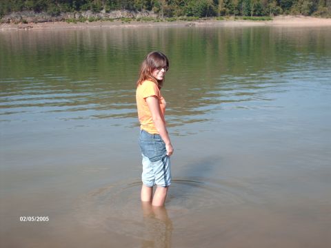 1995 Ford Probe - A woman wades into the water on a sunny day, with trees visible in the background.