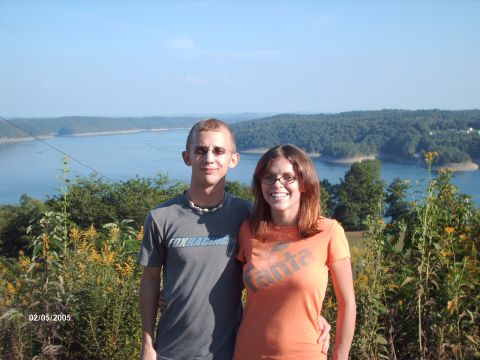 1995 Ford Probe - Couple poses for a photo with a scenic lake and hills in the background.