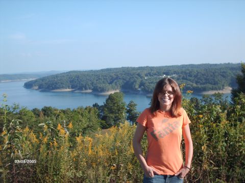 1995 Ford Probe - A woman poses for a photo with a scenic view of a lake and forested hills in the background.