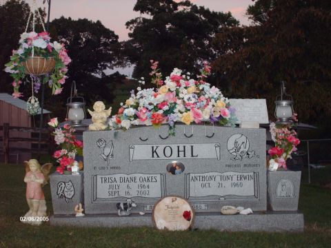 1995 Ford Probe - A cemetery scene at dusk, gravestones adorned with floral arrangements and angelic statues.