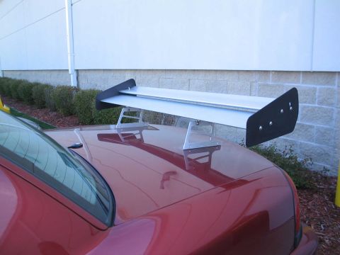 2001 Ford Crown Victoria - A large aftermarket spoiler is attached to the trunk of a red car.