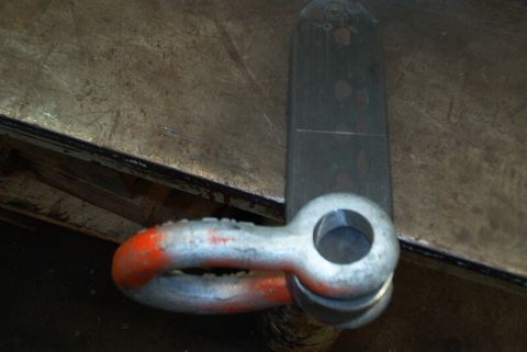 1983 Ford Bronco - A close-up view of a metal tow hitch shackle, showing its connection point and some orange paint markings.