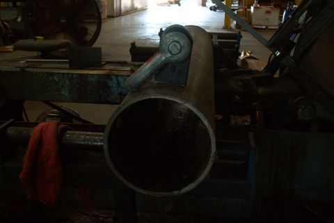 1983 Ford Bronco - Close-up of a large metal pipe secured by a clamp on a piece of industrial equipment.
