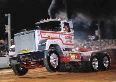 1994 Ford F-150 - Custom semi-truck competes in a truck pull event, kicking up smoke.