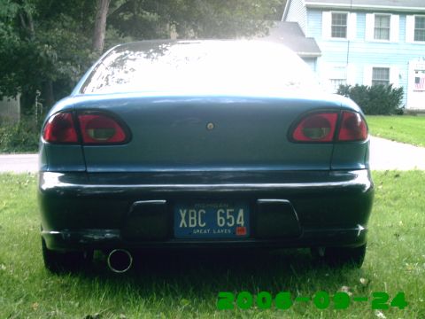 1996 Chevrolet Cavalier - Rear view of a blue 1996 Chevrolet Cavalier sedan parked on grass with a house in the background.