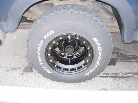 1993 Ford Bronco - A BFGoodrich All-Terrain T/A tire is mounted on a black beadlock wheel, showing off its aggressive tread pattern.