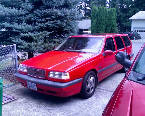 1987 Volkswagen Golf - A red Volvo wagon is parked in a driveway next to another red vehicle.