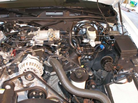 2001 Ford Crown Victoria - Close-up view of the engine bay, highlighting the throttle body and alternator assembly.