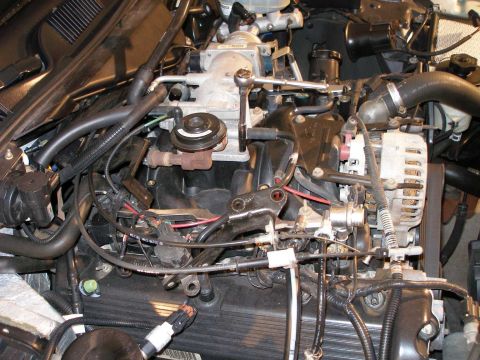 2001 Ford Crown Victoria - Close-up of engine components including throttle body, alternator, and wiring harness.
