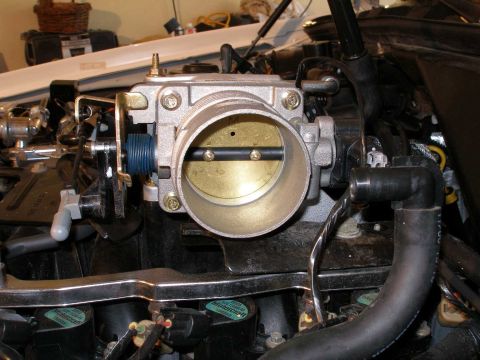 2001 Ford Crown Victoria - A close-up view of a vehicle's throttle body, showing the internal butterfly valve and surrounding mechanical components.
