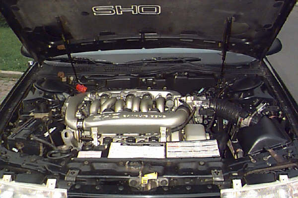 1993 Ford Taurus SHO engine bay with hood open, showing V6 engine and intake system
