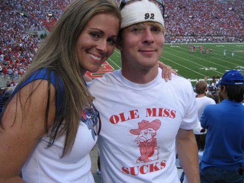 1994 Ford Bronco - A couple smiles for a photo at a football stadium, with a field and spectators visible in the background.